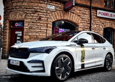 Vit bil parkerad vid byggnad - körkort i Stockholm